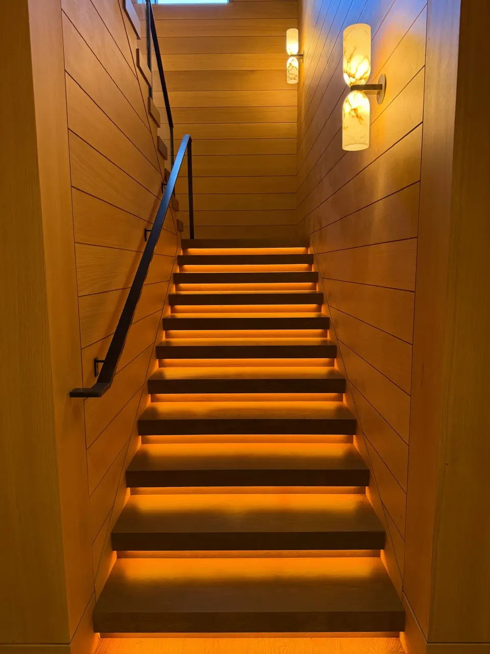 Enclosed oak staircase with LED strip lighting under each tread nosing