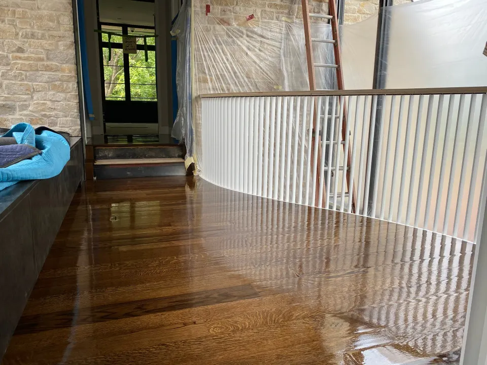 Freshly coated hardwood floor on an upper landing, still glossy from the new finish
