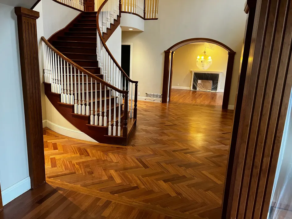 Herringbone parquet foyer with a curved staircase