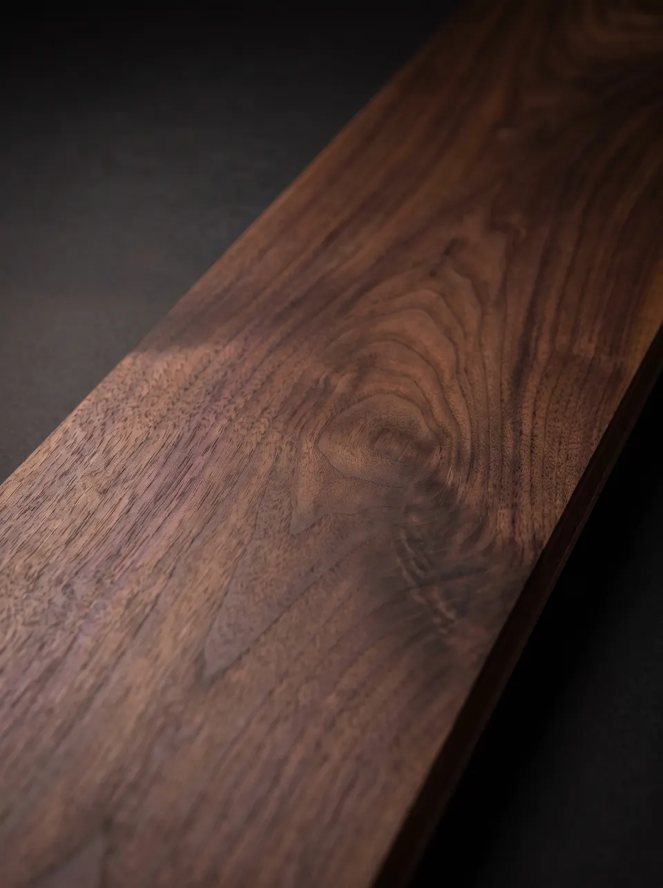 Close view of a black walnut plank showing deep brown heartwood and ribbon grain