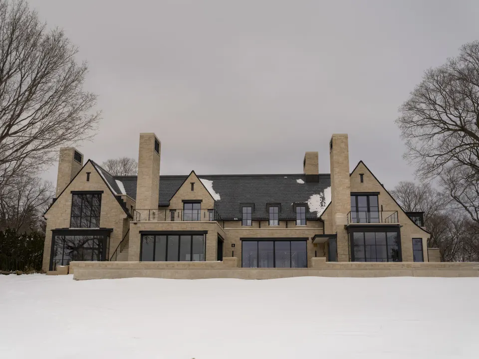Stone lake home exterior in winter