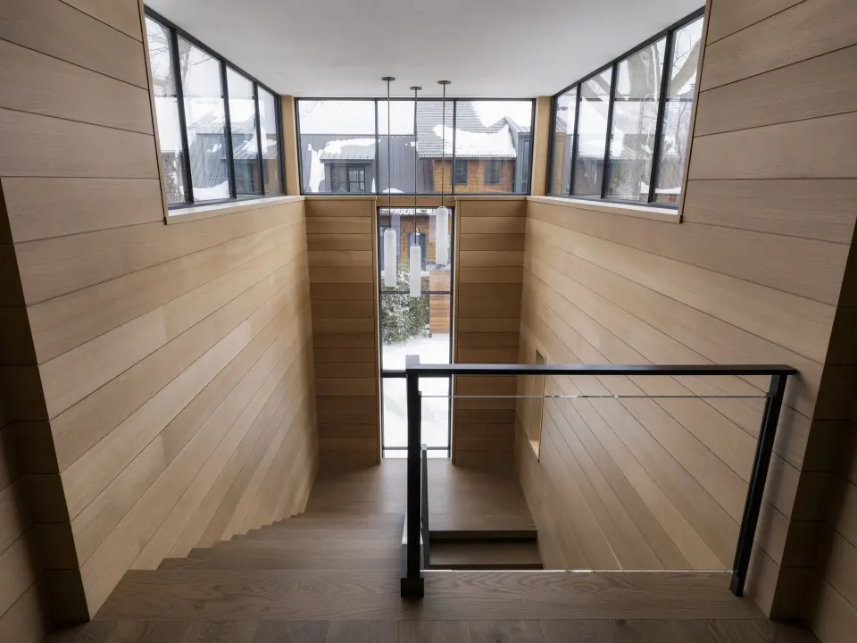 White oak paneled stairwell lit by clerestory windows